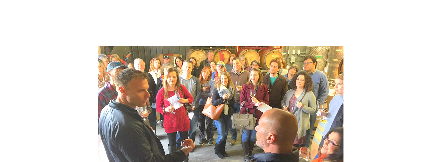 Markus talks with Joey Medaloni at his winery as a small crowd of Joey's club members look on.