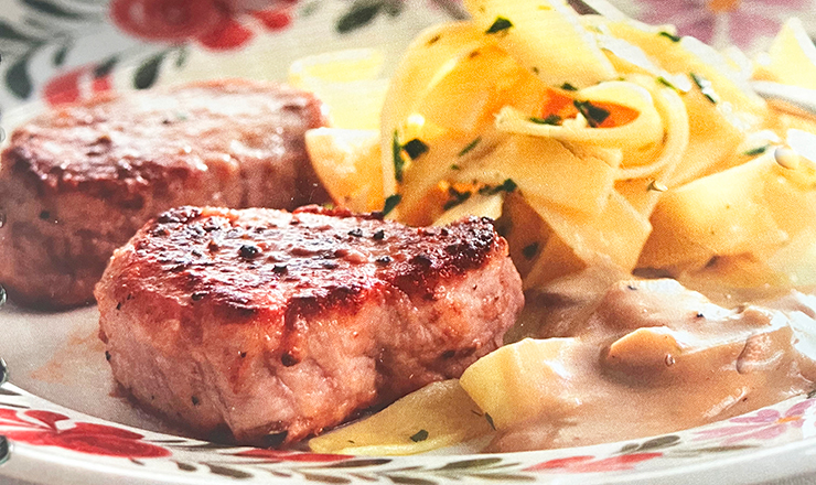 Pork chops with wide pasta displayed on a plate.